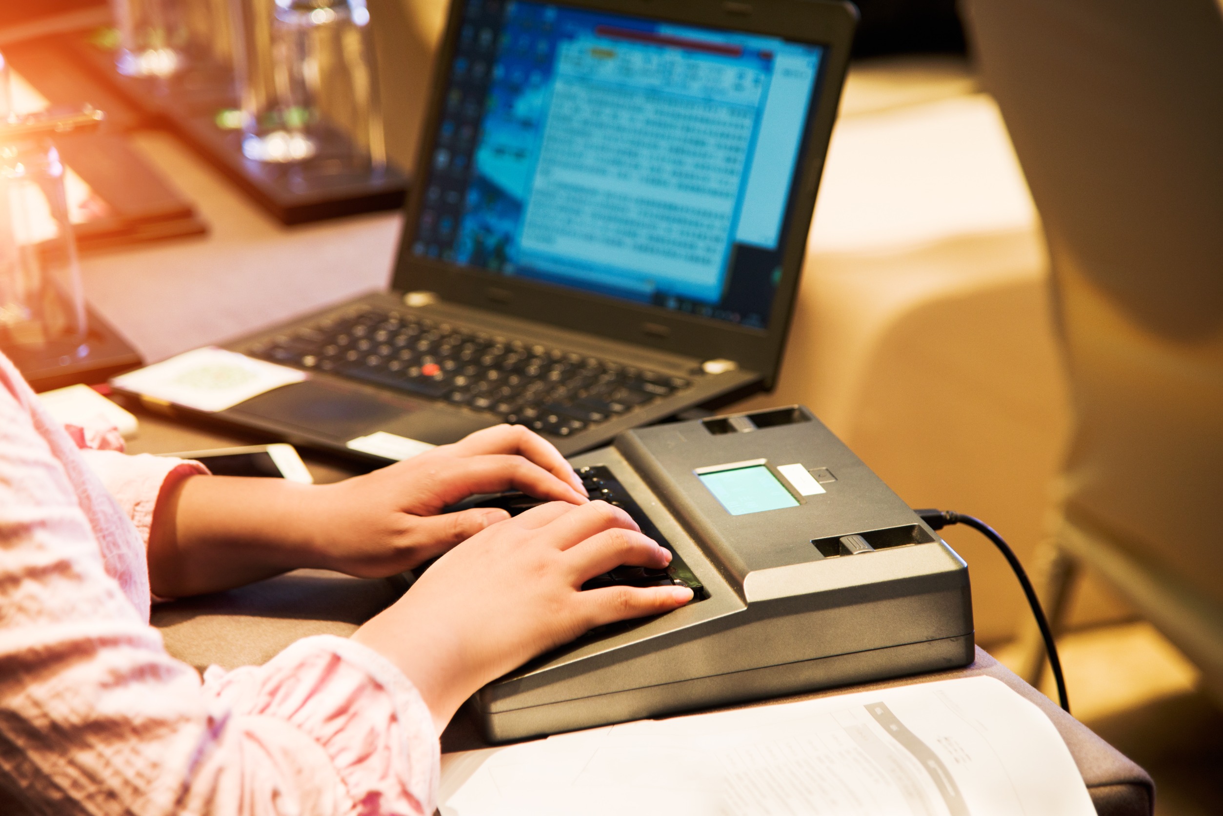 Lady typing the words being spoken in court on a laptop.